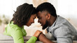 © Prostock-studio - Tender Moment. Romantic Black Couple Bonding At Home, Holding Hands And Touching Foreheads, Relaxing On Couch Together