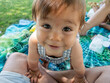© mahalo studio/Stocksy - Adorable baby boy smiling and crawling on parents during picnic