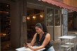 © Taís Luna/Stocksy - Latin Woman Using Her Phone Outdoors