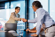 © BONNINSTUDIO/Stocksy - Financial advisor shaking hands with client in meeting