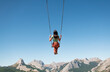© Ibai Acevedo/Stocksy - Swinging woman enjoying peaceful mountain view