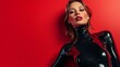 © Ilona - Sexy young woman in latex black clothing posing on blank red background with space for text or inscriptions, latex sexy costume