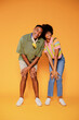 © BONNINSTUDIO/Stocksy - Couple laughing and having fun posing on orange background