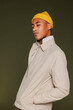 © BONNINSTUDIO/Stocksy - Serious man with yellow beanie posing with hand in pocket