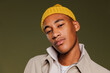 © BONNINSTUDIO/Stocksy - Man with yellow beanie posing confidently in studio