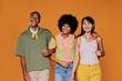 © BONNINSTUDIO/Stocksy - Three friends walking and smiling on orange background