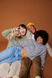 © BONNINSTUDIO/Stocksy - Friends having fun posing on brown background