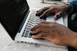 © Ezequiel Giménez/Stocksy - Hands typing on laptop keyboard at outdoor table