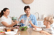 © Pixel-Shot - Parents with their little son and glasses of water eating Fajita at table in kitchen