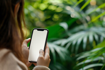 Mockup A woman using a phone with a blank screen in front of a green backdrop Perfect for showcasing app designs or website interfaces