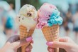 © Vitalii Shkurko - Two hands hold ice cream cones featuring pink, blue, and yellow scoops, set against a vibrant beach backdrop on a sunny afternoon