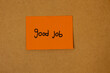 © Answer 7 - Orange sticky note paper with text saying good job written on it, stuck on a brown board, concept of job recognition