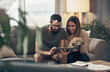 © N F/peopleimages.com - Home, happy couple and digital with tablet for finance, track expenses and success for bank loan. Coffee, woman and man with online budget for taxes review, handle savings and mortgage bills on sofa