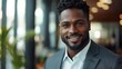 © BlackBird Studio - Confident Businessman Smiling in Modern Office Environment