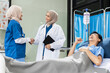 © NINENII - medicine, healthcare and people concept - doctor talking to male patient at bed in hospital..
