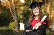 © New Africa - Happy student with diploma after graduation ceremony outdoors, space for text