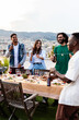© Xavier Lorenzo - Multiracial friends having fun together drinking and dancing at summer party on rooftop terrace