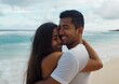 © Kartika - A man and woman are hugging on a beach