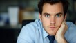 © KN Studio - Worried Businessman: A pensive businessman sits at his desk, his hand resting on his chin, his gaze fixed on the camera with a look of concern. He's lost in thought.
