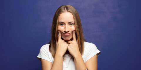 Wall Mural - smiling confidently pointing to own fake smile