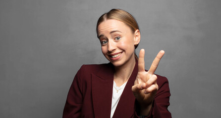 Wall Mural - smiling and looking happy, carefree and positive, gesturing victory or peace with one hand