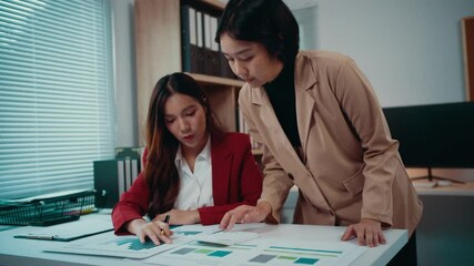 Aufkleber - Two asian businesswomen are having a discussion about their business. They are analyzing financial charts, graphs and data