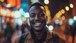 © Zikie_ - African man smiling looking at camera with blurred city lights background.