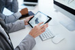 © peopleimages.com - Business people, hands and bookkeeping with tablet screen for chart, graph or company expenses at office desk. Closeup, employees or colleagues with display for financial data, budget or analysis