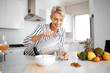 © peopleimages.com - Mature woman, blender and glass in kitchen with smoothie for nutrition, wellness and meal prep in home. Person, fruit and smile for drink, detox and gut health with ingredients in morning at house