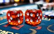© PlenyunGraphics - Two red dice on a green felt casino table with chips in the background.