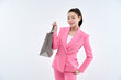 © PHOTOGRAPHER JH - Beautiful Asian woman wearing pink suit holding gray shopping bag in hand in various poses.