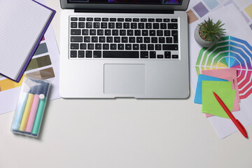Poster - Designer's workplace with laptop, stationery and palettes on white table, flat lay. Space for text