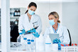 © peopleimages.com - Women, scientist and discussion in lab with notes, tablet and review for experiment results at pharma company. People, mentor and feedback with face mask, ppe and medical research for mpox vaccine