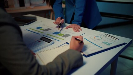 Fototapete - Business partners discussing their strategy while reviewing charts and analyzing data. The collaboration takes place in an office setting, focusing on teamwork and planning for success