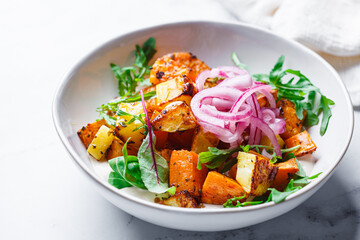 Baked potato and sweet potato wedges with hummus and pickled red onion.