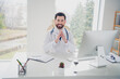 © deagreez - Photo of qualified doctor guy sit table desk listen online web consultation in clinic room