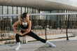 © BGStock72 - Fitness enthusiast stretches outdoors in modern urban environment during sunset, showcasing dedication to health and wellness