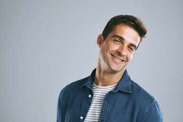 Fototapete - Man, portrait and happiness in studio for positive mood, confidence and pride with gray background. Male person, space and employee for creative agency, design and career growth with smile in Spain