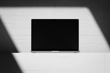 Wall Mural - Scene with an open laptop with a blank screen on a concrete background