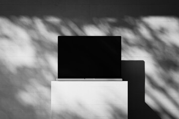 Wall Mural - Scene with an open laptop with a blank screen on a concrete background