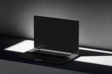Wall Mural - Scene with an open laptop with a blank screen on a concrete background