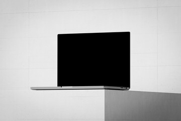 Wall Mural - scene with an open laptop with a blank screen on a concrete background