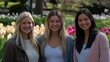 © kvladimirv - Three Smiling Women in a Vibrant Spring Garden with Tulips