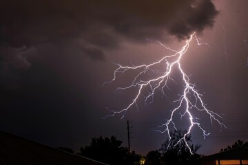 Wall Mural - powerful lightning flash illuminates the night sky during a thunderstorm shallow depth of field