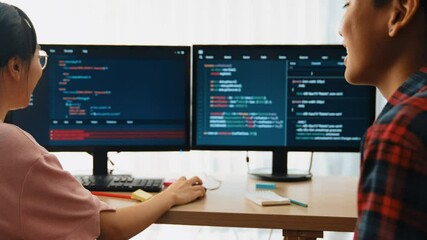 Slow motion back end software developer engineer for computer programming working together on debugging writing computing code, solving complex algorithms display on monitor in office. Burgeoning