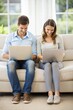 © Tekin - Young Couple Using Laptops In Couch