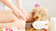 © Prostock-studio - Female hands do massage on girl shoulders, lying on table with white towel, near orchid and aroma candles