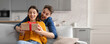 © Prostock-studio - A man surprises his partner with a beautifully wrapped gift in a stylish living room. The atmosphere is filled with excitement and happiness as they share this special moment together.