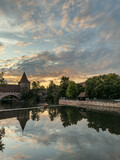 Fototapeta Koty - Schlayerturm medieval tower and Kettensteg (Chain Bridge) over river Pegnitz at sunset