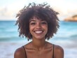 © bvbflo1 - A woman with an afro smiling at the camera on a beach